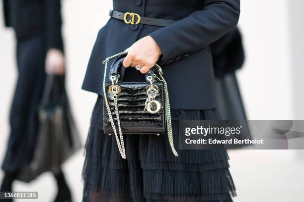Guest wears a black blazer jacket from Dior, a black shiny leather with gold CD buckle belt from Dior, a black ruffled tulle midi skirt, a black...