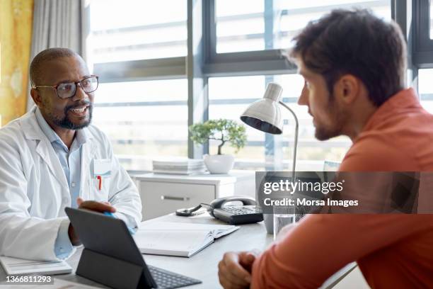 male doctor discussing with patient in clinic - 医者　患者 ストックフォトと画像