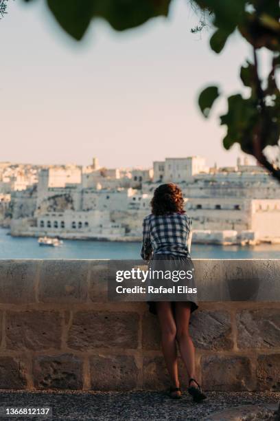 rear view of stylish lady looking at the breakwater - valletta stock pictures, royalty-free photos & images