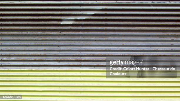weathered gray and yellow corrugated metal sheet in paris - iron roll stock pictures, royalty-free photos & images