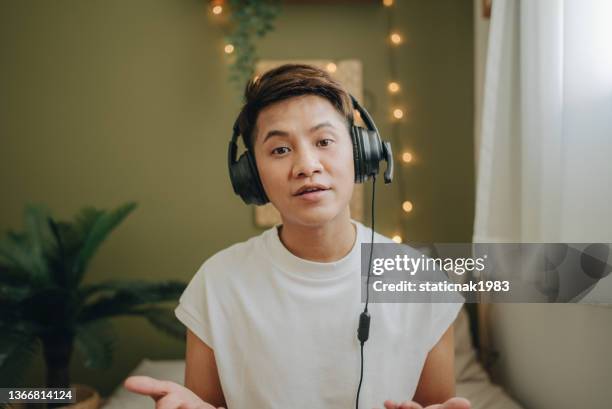 businessman wearing wireless headphones making video call on laptop. camera point of view - male influencer stock pictures, royalty-free photos & images