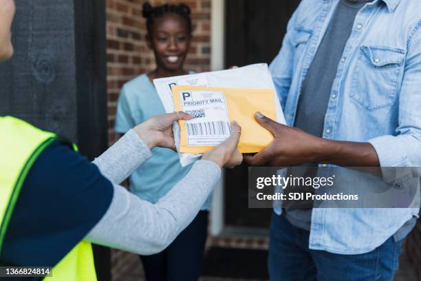 daughter watches unrecognizable dad receive mail from unrecognizable delivery person - tag 11 stock pictures, royalty-free photos & images