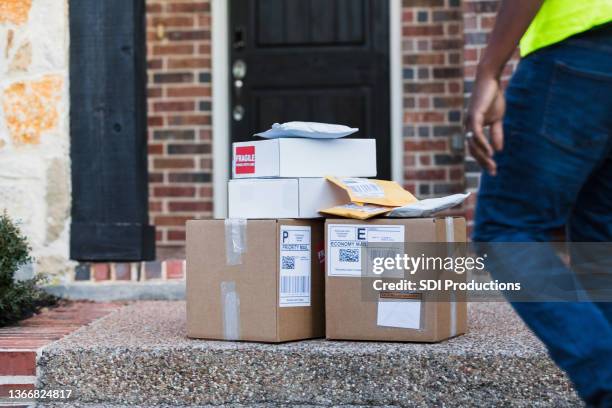 unrecognizable delivery man approaches stack of mail for pick-up - delivery driver stock pictures, royalty-free photos & images