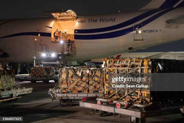 Ground personnel unload weapons, including Javelin anti-tank missiles, and other military hardware delivered on a National Airlines plane by the...