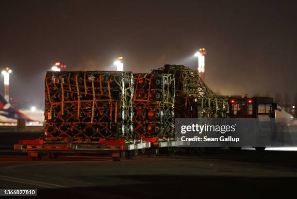 An airport vehicle pulls a portion of a shipment of weapons that include Javelin anti-tank missiles and other military hardware delivered on a...