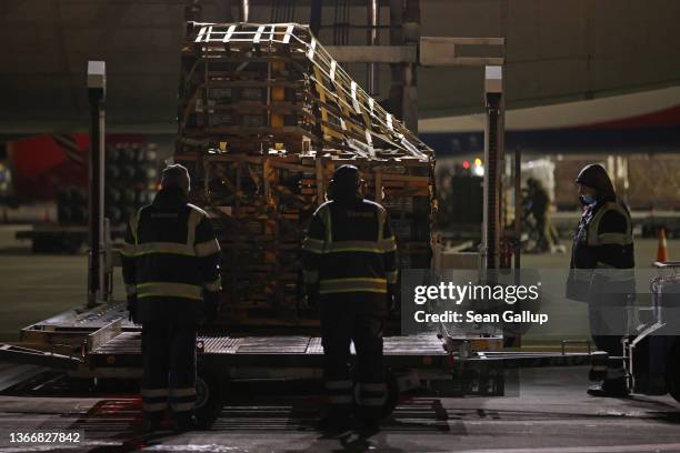 Ground personnel unload weapons, including Javelin anti-tank missiles, and other military hardware delivered on a National Airlines plane by the...