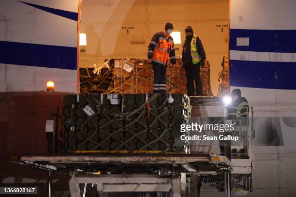 Ground personnel unload weapons, including Javelin anti-tank missiles, and other military hardware delivered on a National Airlines plane by the...