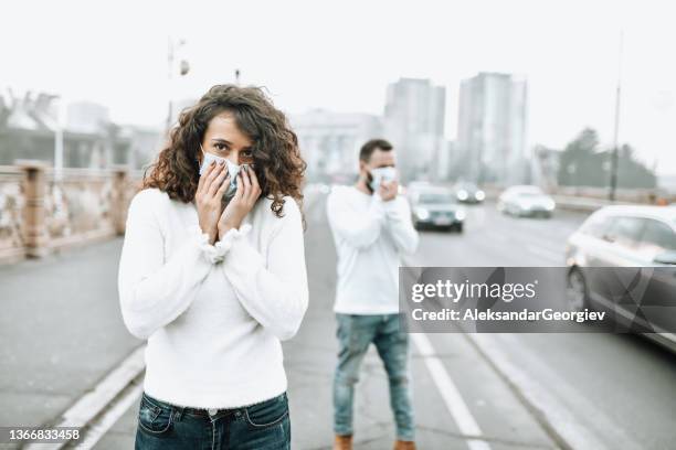 male and female pedestrians with face masks suffocating from polluted air in city center - stifle stock pictures, royalty-free photos & images