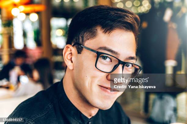 portrait of happy and handsome asian man smiling at camera in public place - korean man 個照片及圖片檔