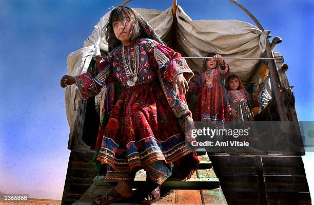 An unidentified Afghan Kuchi nomad child walks down a ramp as other children observe September 4, 2002 in Zhare Dasht, Afghanistan. The Kuchi nomad...