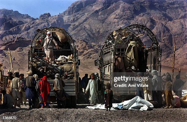 Afghans that were living in a camp for displaced people around Spin Boldak, near the border of Pakistan and southern Afghanistan, stand togehter as...