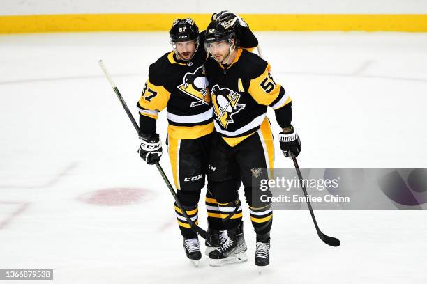 Kris Letang of the Pittsburgh Penguins celebrates his goal with teammate Sidney Crosby during the second period against the Arizona Coyotes at PPG...