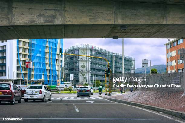 bogotá, colombia - the drivers point of view under the bridge on calle 100 and on to the northbound carriageway of carrera novena in the bario de usaquén on an overcast day. - carrera de calle stock pictures, royalty-free photos & images