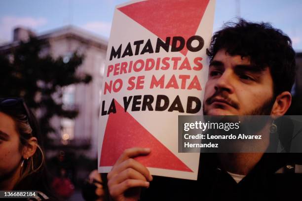 Man holds a banner thats reads "Killing journalists does not kill the truth" during a protest to ask for justice for journalists and photojournalists...