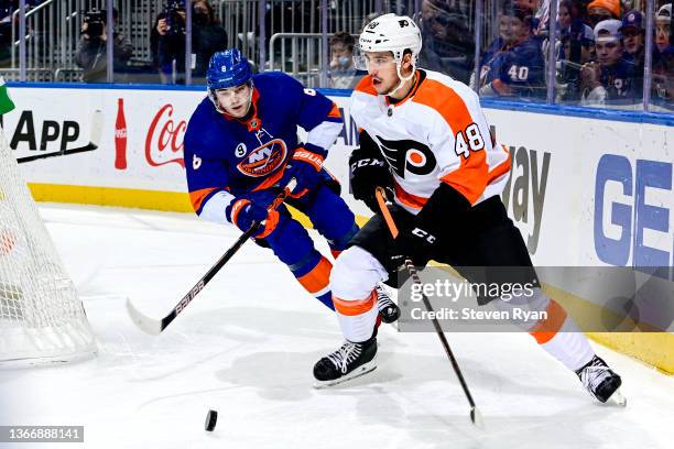 Morgan Frost of the Philadelphia Flyers is defended by Noah Dobson of the New York Islanders during the third period at UBS Arena on January 25, 2022...