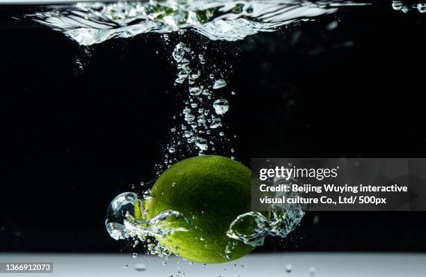 lemon falling into the water - throwing water stock pictures, royalty-free photos & images