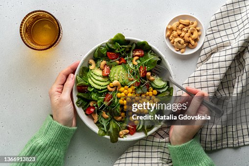 Faceless female eating healthy vegan plant-based salad in bowl with fatty acids and dietary fiber Faceless female eating healthy vegan plant-based salad in bowl with fatty acids and dietary fiber