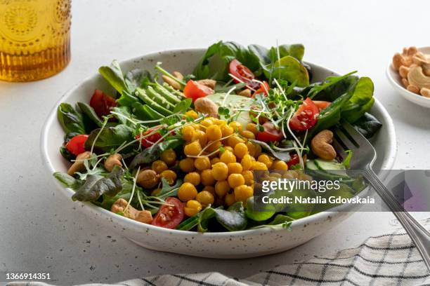 delicious vegan salad with sliced avocado, tomato, pok choi, cashew, chickpea and micro-green - chick pea salad stock pictures, royalty-free photos & images
