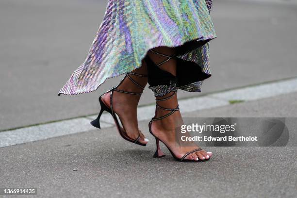 Didi Stone wears a purple and green reflected sequins asymmetric / slit midi dress, black leather with embroidered rhinestones high laces sandals,...