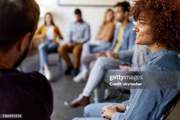 mujer feliz asistiendo a una terapia de grupo. - terapia de grupo fotografías e imágenes de stock