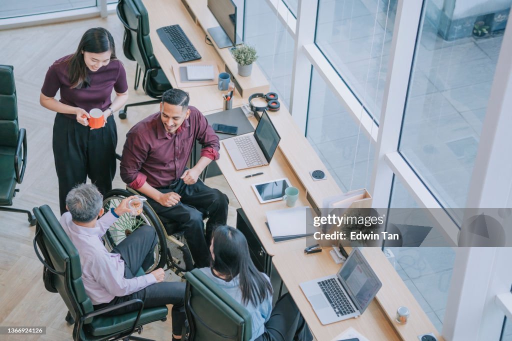 Group of Asian white collar worker having a break taking snack at the workstation office together
