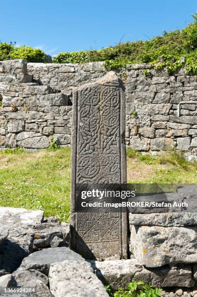 caped shaft, irish gravestone, cemetery, celtic ornaments as decoration, na seacht dteampaill, the seven churches, inis mor, inishmore, arainn, aran islands, aran islands, county galway, ireland - aran islands imagens e fotografias de stock