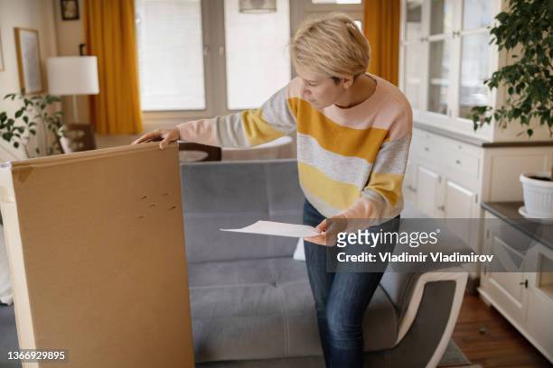 woman holding delivery box - damaged box stock pictures, royalty-free photos & images