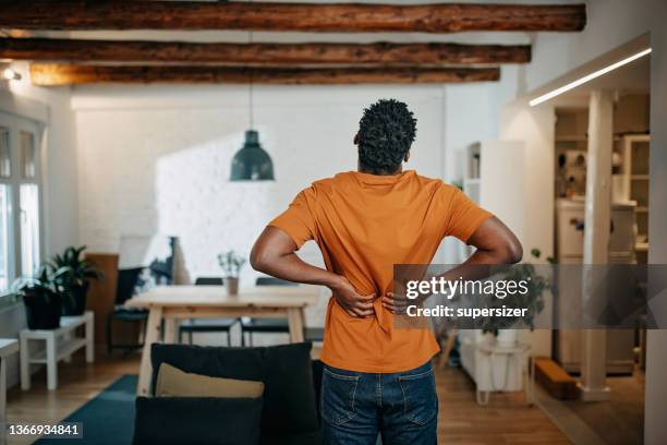 joven afroamericano con dolor - back pain fotografías e imágenes de stock