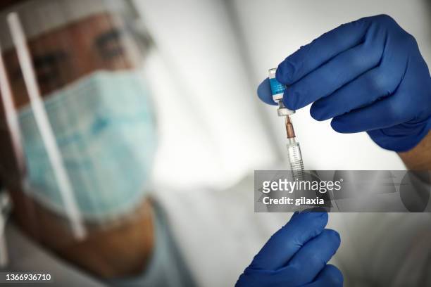 medical worker preparing covid-19 vaccine - covid 19 vaccine vial stock pictures, royalty-free photos & images
