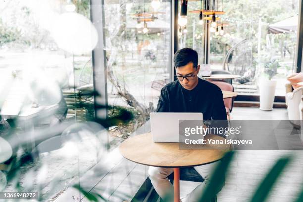 Young Asian entrepreneur trading with laptop in public place