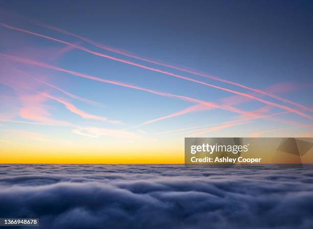 valley mist from a temperature inversion in the lake district at dawn, uk from the summit of red screes with airplane contrails. - slipstream stock pictures, royalty-free photos & images