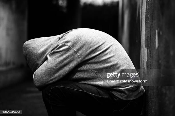 homeless man alone in cold dark subway tunnel in the city - homeless person stockfoto's en -beelden