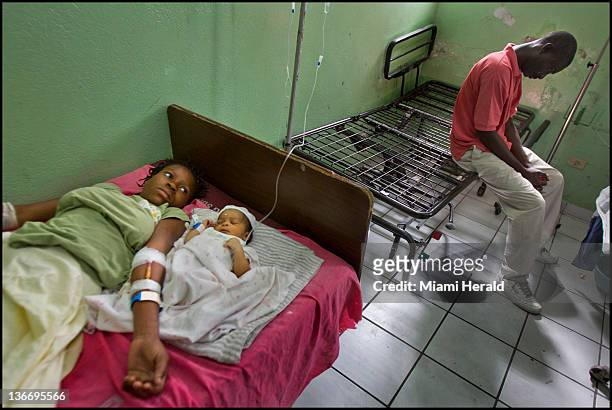Woodlyne Joseph, left, lies with her new baby daughter in the maternity wing at the General Hospital in Port-au-Prince, Haiti, January 4, 2012. Two...