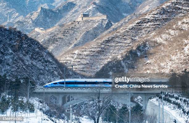 Bullet train of the Beijing-Zhangjiakou high-speed railway line travels past the Juyongguan section of the Great Wall on January 25, 2022 in Beijing,...