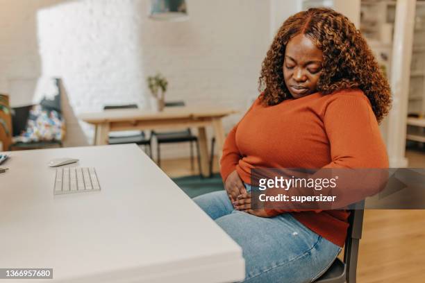 young african-american  woman having stomach pain - endometriosis stock pictures, royalty-free photos & images