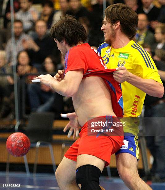 Russia's Mikhail Chipurin gets caught by Sweden's Kim Ekdahl Du Rietz in a friendly handball match Sweden vs Russia at the Kristianstad Arena in...