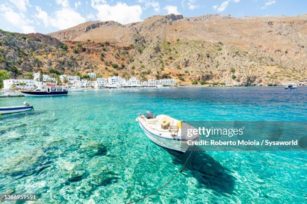 boats moored in the transparent sea, crete - crète photos et images de collection
