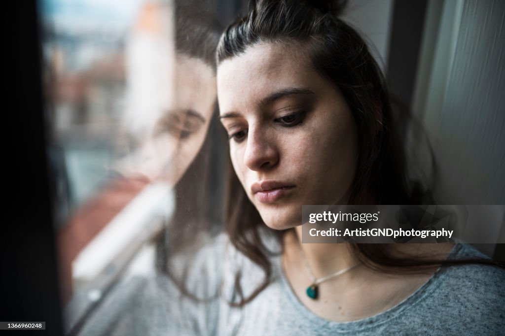Depressed woman by the window.