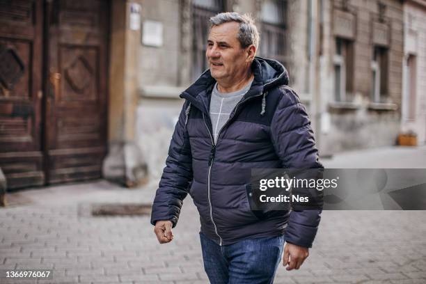 a man walks down the street - man side way looking stock pictures, royalty-free photos & images