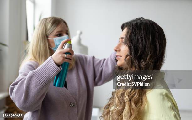 the hairdresser is styling the model's hair in a photo studio. - backstage hairdresser stock pictures, royalty-free photos & images