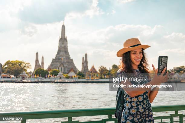 smiling of beautiful tourist woman traveling at wat arun, bangkok on her vacation - holiday asia tourist stockfoto's en -beelden