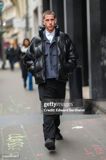 Guest wears a white shirt, a gray cargo jacket, a black shiny high neck puffer jacket, black midi skirt, black flared suit pants, black puffy shoes,...