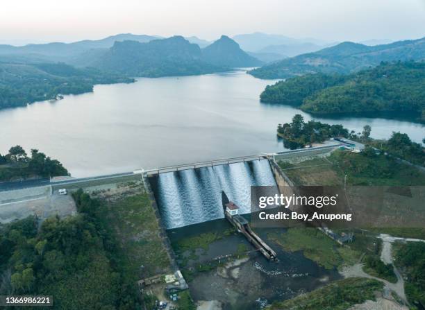 aerial view of mae suai reservoir (or dammed valleys) in chiang rai province of thailand discharging water flows over the spillway into the river below. - stausee stock-fotos und bilder