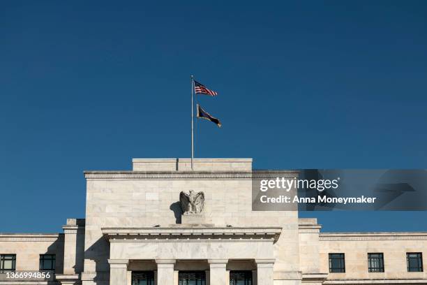 Flags blow in the wind atop the Marriner S. Eccles Federal Reserve building on January 26, 2022 in Washington, DC. Following a two day meeting,...