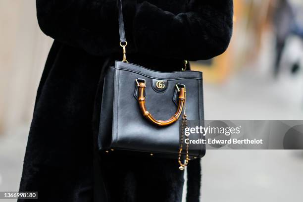 Guest wears a black fur long coat, a black shiny leather Diana crossbody bag from Gucci, outside Alexis Mabille, during Paris Fashion Week - Haute...