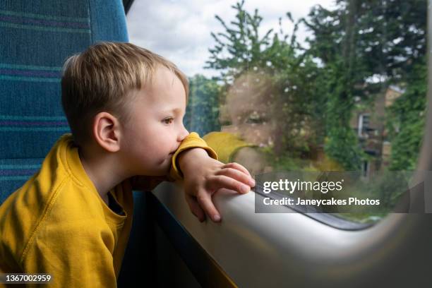 boy looking through window in train - tåginteriör bildbanksfoton och bilder