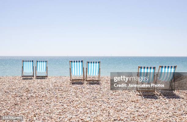 uk, brighton, deckchairs on beach - british coast stock-fotos und bilder