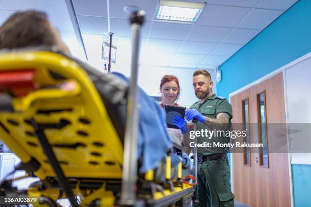 emergency paramedics handing over patient to emergency nurse - paramedic stock pictures, royalty-free photos & images