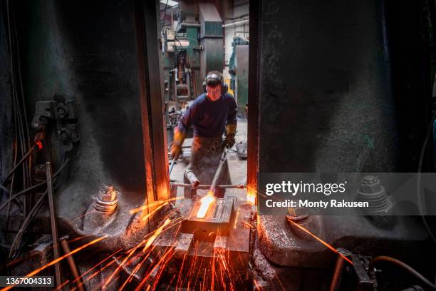 engineer forging steel parts in hammer press in industrial forge - forge hammer stock-fotos und bilder