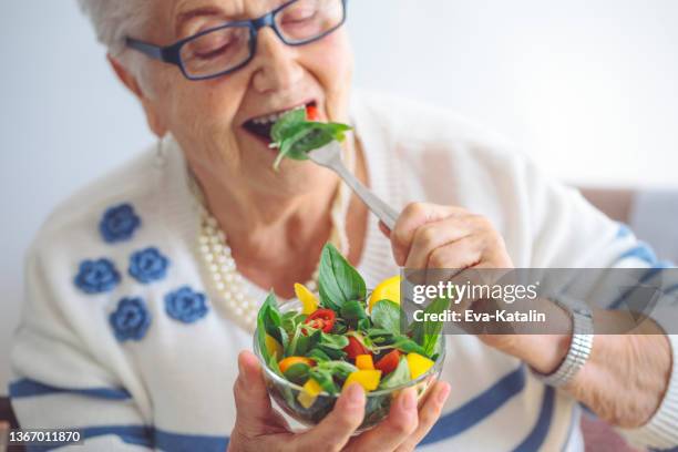 senior woman at home - green salad stock pictures, royalty-free photos & images